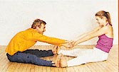 Sit face-to-face, legs spread, feet touching; cross wrists and hold hands. Lean back, pulling him toward you; reverse. Do three times.